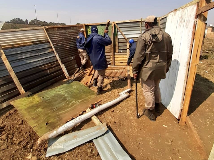 JMPD officers remove illegal structures erected in Freedom Park, Johannesburg.