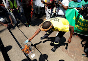 A protester adds his mask to the burning pile as a symbol of his opposition to government violating people's freedom of choice