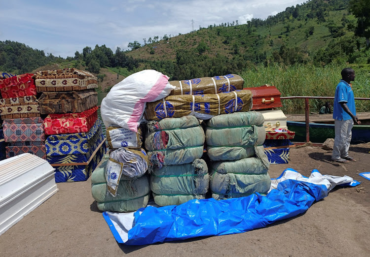 Workers arrange humanitarian relief and coffins for the Congolese civilians killed following rains that destroyed the remote, mountainous area and ripped through the riverside villages of Nyamukubi, Kalehe territory in South Kivu province of the Democratic Republic of Congo May 9, 2023.