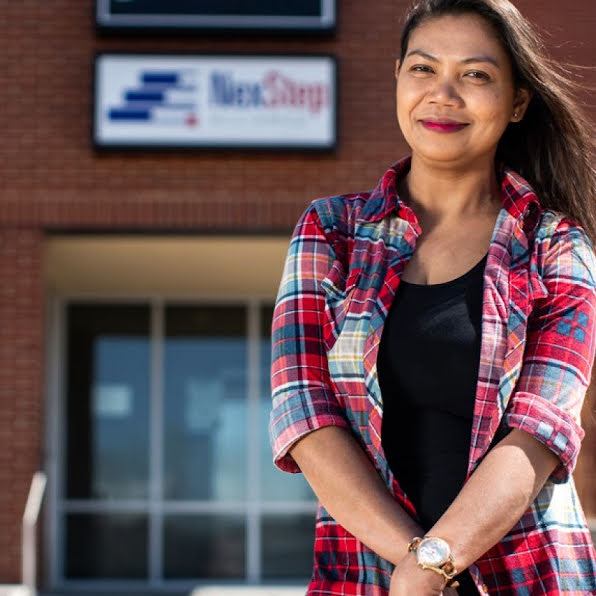 Smiling woman standing in front of a Goodwill location.