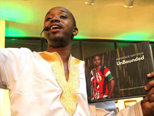 A file photo of activist Boniface Mwangi holding a copy of his book 'Unbounded'. /ENOS TECHE