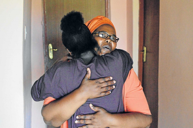 Khayakazi Mabona hugs her daughter, Saphetha, at their home in Peddie after checking out a highly suspicious work contract from Uganda.