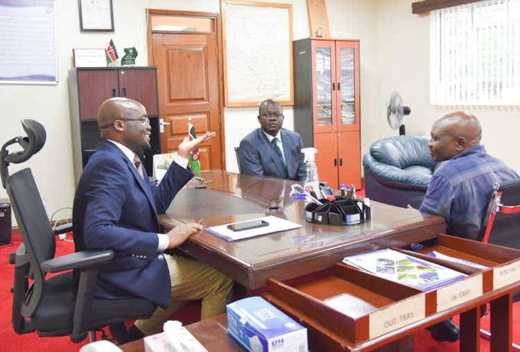 Raymond Omollo Interior PS hands over to Wycliffe Ochiaga who has been appointed the acting Managing Director of the Lake Basin Development Authority (LBDA) in Kisumu.