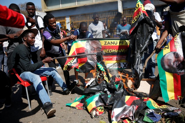 Supporters of the opposition Movement for Democratic Change party (MDC) of Nelson Chamisa burn an election banner with the face of Zimbabwe's President Emmerson Mnangagwa in Harare, Zimbabwe, August 1, 2018.