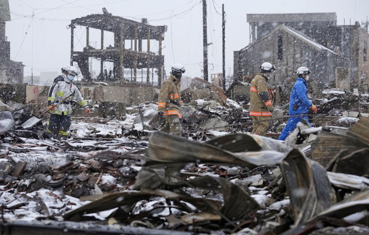 Rescuers search for victims in the snowfall at a residential and commercial site following an earthquake in Wajima, Ishikawa Prefecture, Japan, January 7 2024. Picture: KYODO/REUTERS