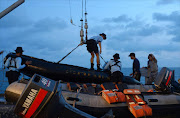 Members of the Indonesian Navy prepare equipment to be lowered into the water from the vessel KRI Banda Aceh to conduct operations to lift the tail of AirAsia flight QZ8501 in the Java Sea on January 9, 2015. Ping signals from the black box data recorders of crashed AirAsia Flight QZ8501 were detected on January 9, a senior Indonesian search official told AFP. AFP PHOTO / POOL / ADEK BERRY