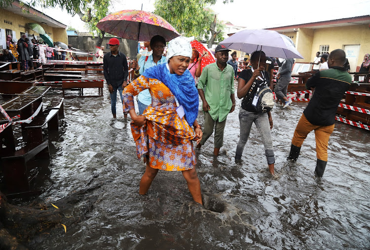 Voters wade through flood water at a polling station during the presidential election in Kinshasa, Democratic Republic of Congo, on December 30 2018.