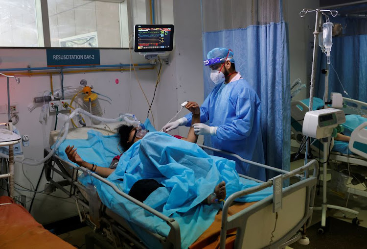 A medical worker tends to a patient suffering from coronavirus disease (COVID-19), as a Syringe Infusion Pump, donated by France is seen next to his bed, inside the emergency room of Safdarjung Hospital in New Delhi, India, May 7, 2021. REUTERS/Adnan Abidi