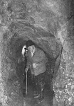 oude man met wandelstok in rotsgang met blokje (arsenicum?) in de hand