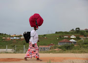 A member of  Ebuhleni Nazareth Baptist Church walks with her luggage to eKhenani mountain in Ozwathini, KwaZulu-Natal, to which they made their annual holy pilgrimage.