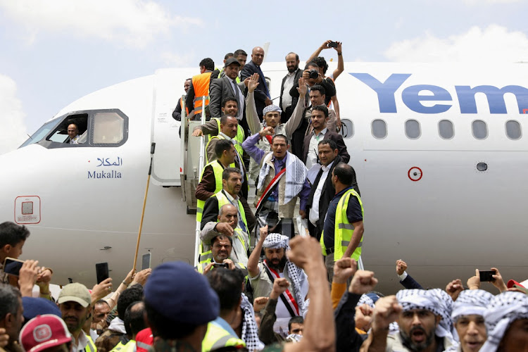 Freed prisoners exit an International Committee of the Red Cross (ICRC)-chartered plane after it arrived at Sanaa Airport in Sanaa, Yemen, on Friday. Picture: REUTERS/KHALED ABDULLAH