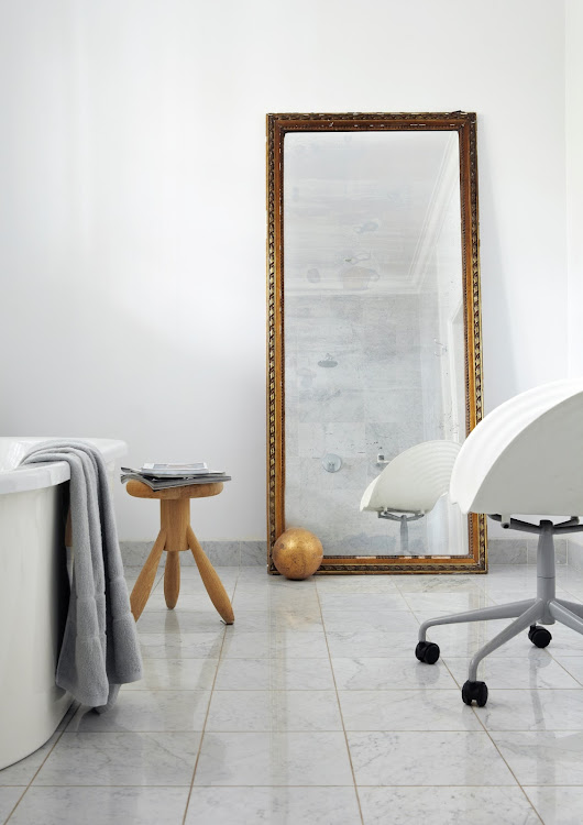 In the generously proportioned bathroom, a Tom Vac Swivel Chair by Ron Arad for Vitra and a Baby Rocket stool by Eero Aarnio make up its sparse furnishings.