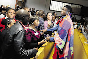 Supporters console truck driver Sanele May in the Pinetown magistrate's court at his first court appearance in 2013. May is wearing a hand-stitched blanket made by a support group member.