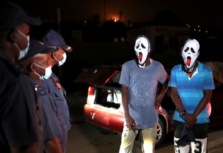 Police officers stop men wearing masks during a patrol as a nighttime curfew is reimposed amid a nationwide coronavirus lockdown in Pretoria on January 9 2021.