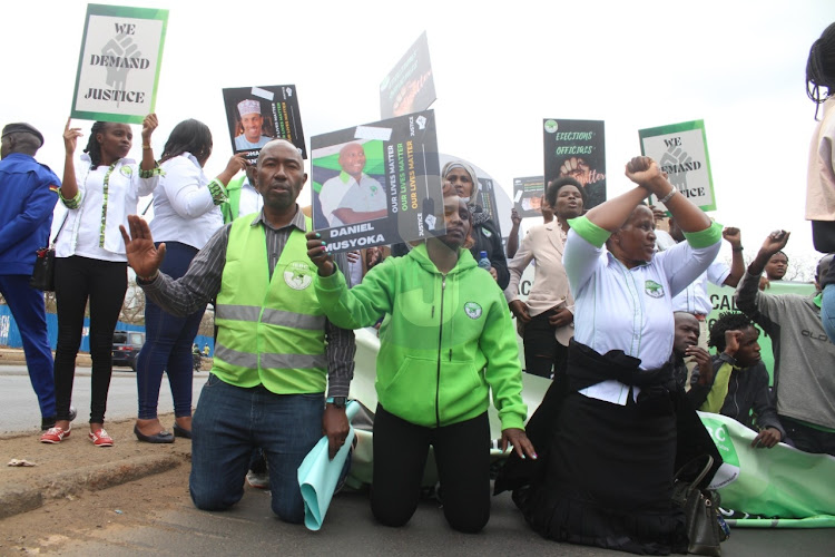 IEBC officials and activists carry banners with portraits of election officials said to have been attacked, disappeared or killed during the general election as they hold a demonstration condemning attacks on election officials at Nairobi on August 25, 2022.