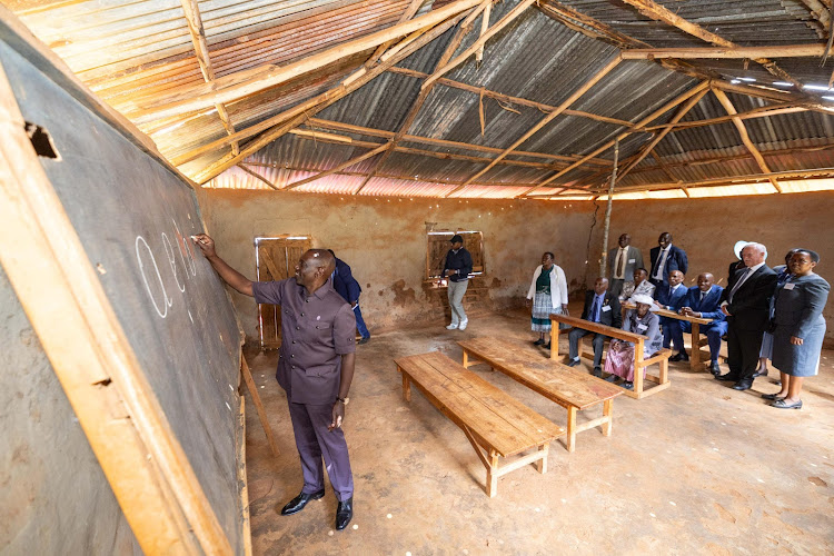 President William Ruto writing on a blackboard at Kamagut Primary School in Turbo, Uasin Gishu on January 8, 2024