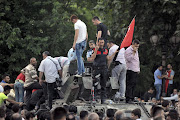 A Turkish policeman and other people stand atop of a military vehicle in Ankara, Turkey July 16, 2016. REUTERS/Stringer