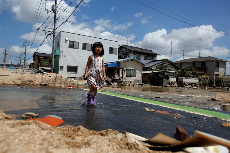 A girl walks in a flood affected area in Mabi town in Kurashiki, Okayama Prefecture, Japan, July 10, 2018.