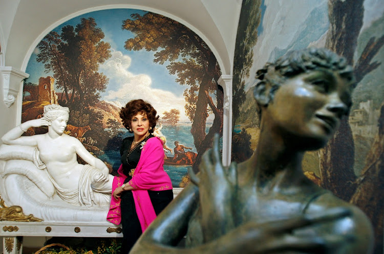 Italian film icon Gina Lollobrigida poses near two of her sculptures in her villa in southern Rome December 7, 2006.
