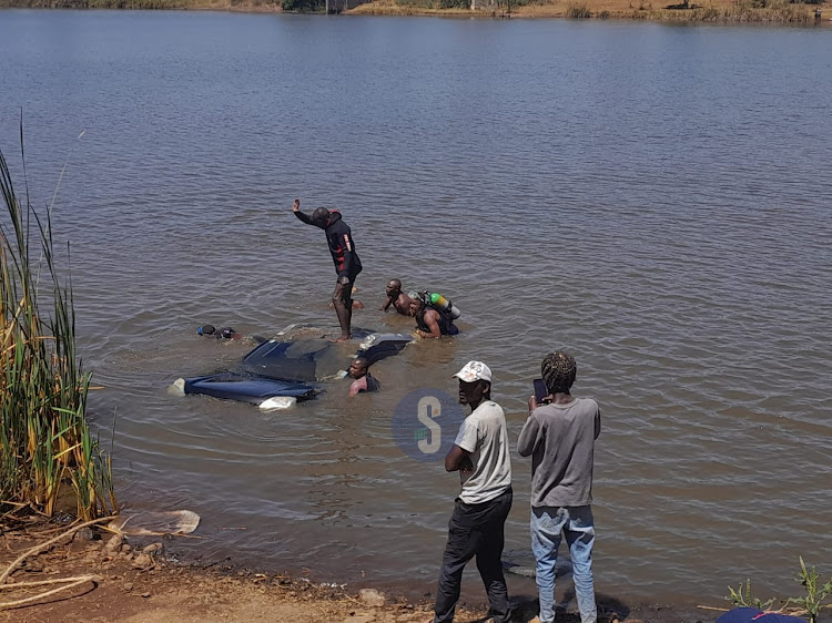 Divers together with officers from the Kiambu Fire and Disaster response team retrieve the car that plunged into a dam in Toll area, Juja subcounty on January 18.