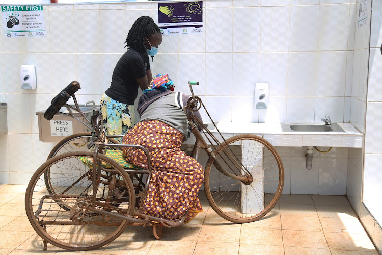 A pedestrian using the handwashing facility at the Busia border point