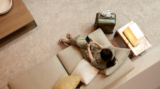 Une image d'une femme utilisant Google Home dans le salon