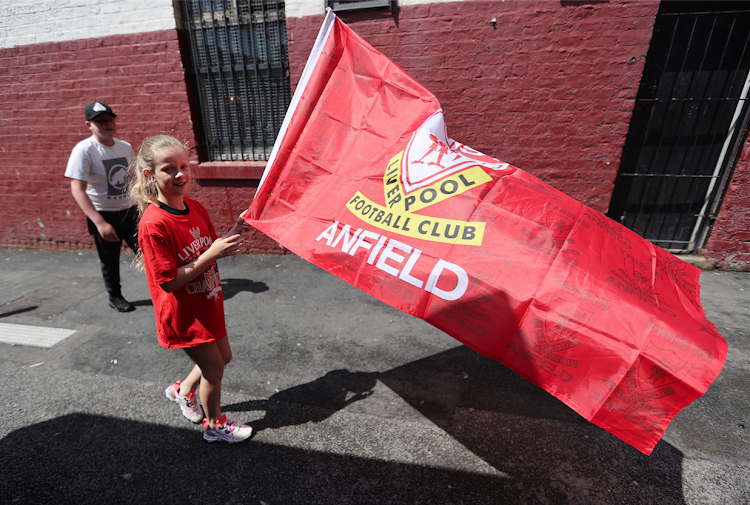 A fan waves a flag after Liverpool were crowned Premier League champions