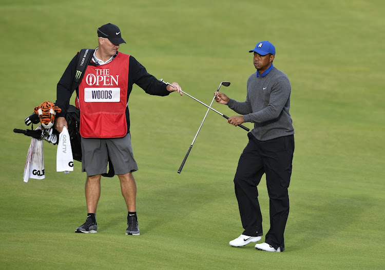 Tiger Woods exchanges clubs with caddie Joe Lacava on the 18th hole during the first round of The Open Championship golf tournament at Royal Portrush Golf Club in Portrush, Ireland, on July 18, 2019.