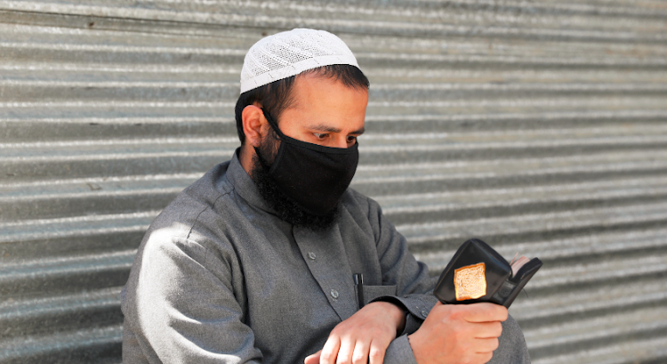 An Afghan man reads the Koran on the first day of the holy fasting month of Ramadan, amid the spread of the coronavirus disease (COVID-19), in Kabul, Afghanistan April 24 2020.