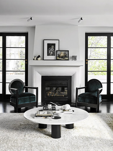 French doors in the living room create symmetry, which turns the spotlight on the hand-carved fireplace.