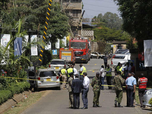 Eplosives experts gather evidence from the car suspected to have been used by the attackers outside DusitD2