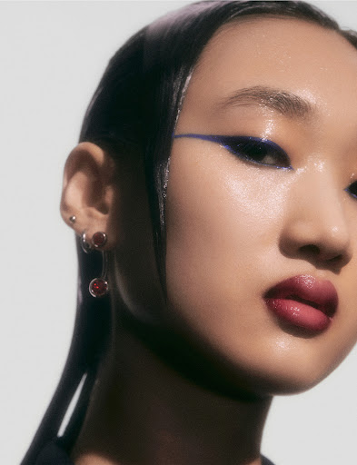 Model Erin Shin in blue eyeliner with slicked back black hair.