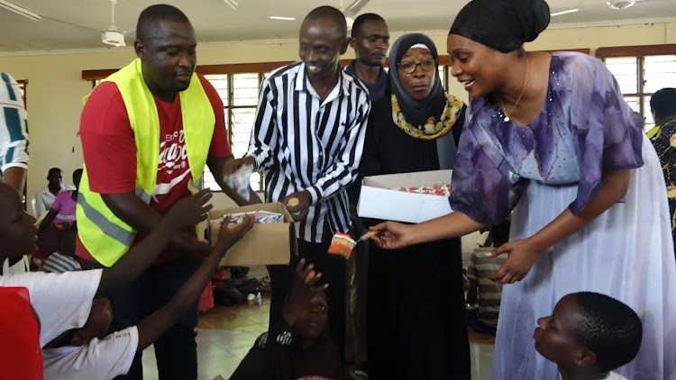 Malindi MP Amina Mnyazi shares cakes to orphans and people living with disability during celebrations with them at the Goshi' chief's grounds