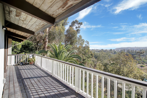 Wooden balcony overlooking lush greenery in this luxury house for sale in Malibu ($4,295,000)