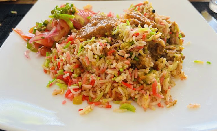 A plate of chicken biriyani served with kachumbari