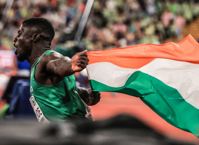 Israel Olatunde running with the Irish flag