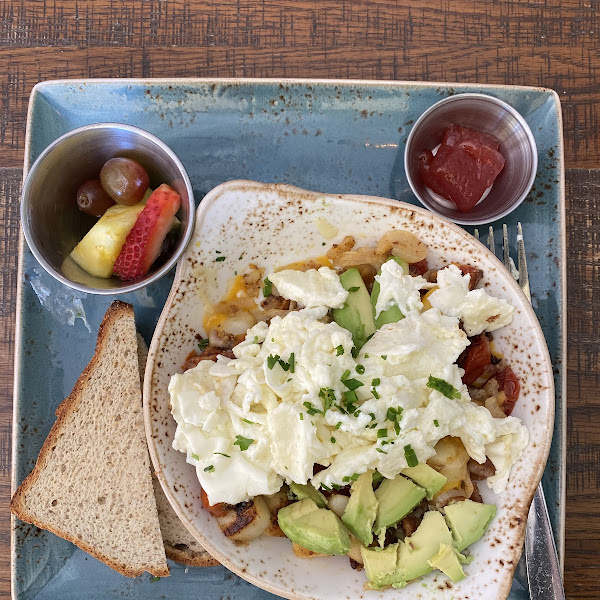 Farmhouse Egg Hash with egg whites and light on the cheese. Really good! Potatoes, avocado, bacon, tomatoes, caramelized onions, jack and cheddar cheese. Udi’s GF toast.