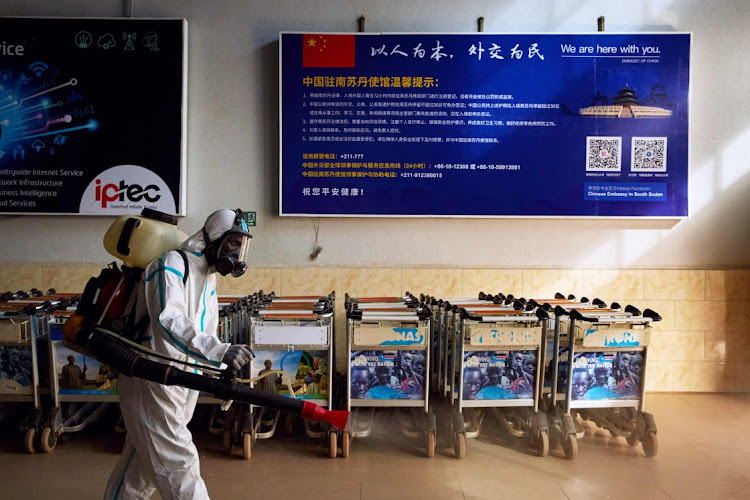 An airport staff member disinfects Juba International Airport in Juba, South Sudan.