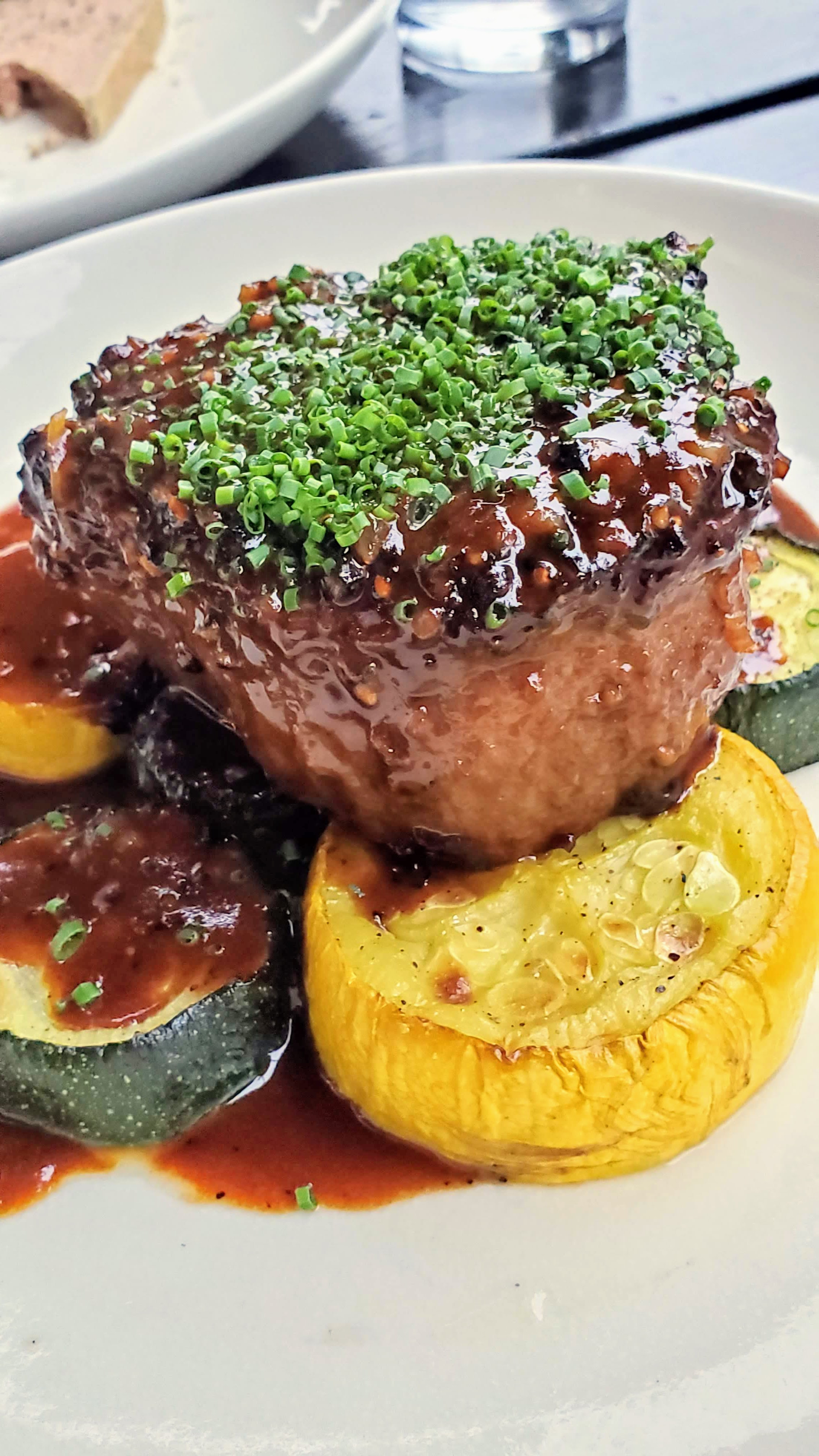 Recommendations at Bistro Agnes: Filet Mignon Au Poivre, a 6 oz black pepper-crusted beef tenderloin, madeira cream, roasted zucchini & summer squash shown