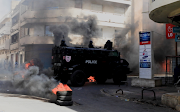 A security forces vehicle drive past burning tyres as supporters of opposition leader Ousmane Sonko, who was arrested following sexual assault accusations, demonstrate in Dakar, Senegal on March 5 2021. 
