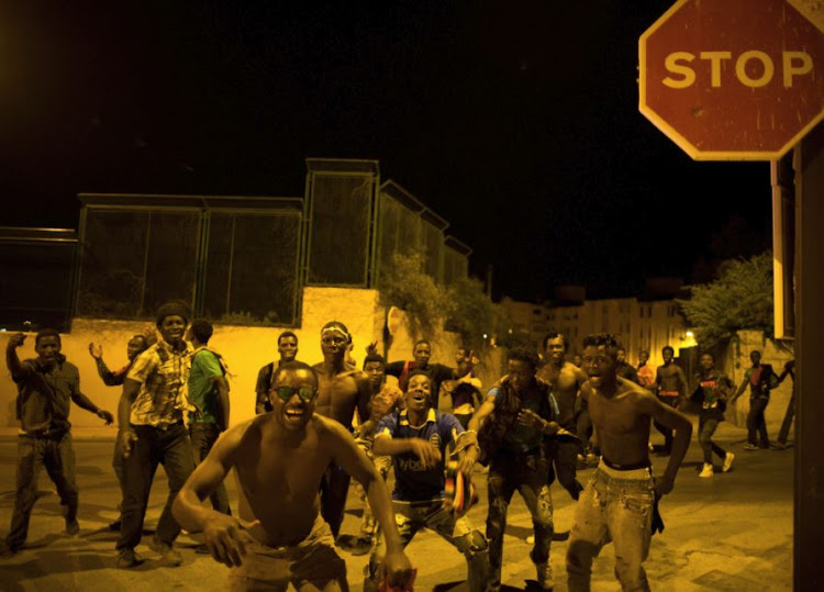 African migrants react after crossing the border from Morocco to Spain's North African enclave of Ceuta, Spain, early August 1, 2017.