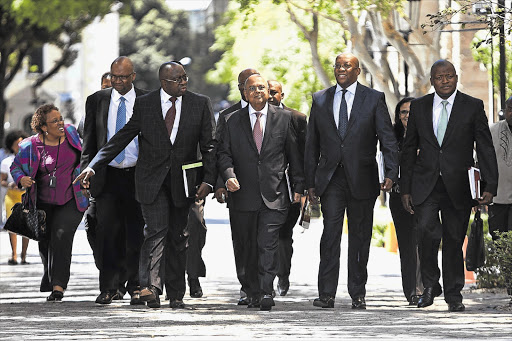 Minister of Finance Pravin Gordhan, centre, and his team arrive at parliament yesterday for his Budget presentation