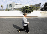 ON THE WARPATH: Christine Phillips walks past the house of her neighbour David Bradbury, whom she accuses of flouting building regulations and devaluing her property