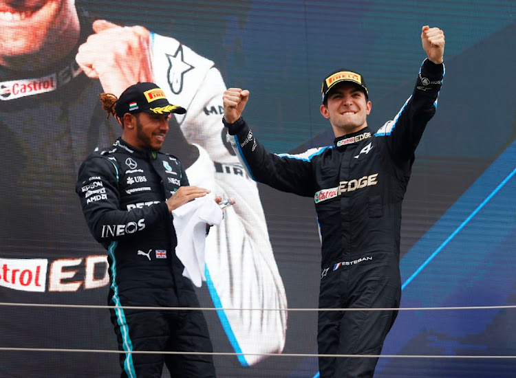 Winner Esteban Ocon of Alpine celebrates on the podium alongside Lewis Hamilton of Mercedes after the Hungarian Grand Prix, Budapest on August 1, 2021