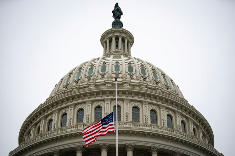 The American flag flies at half staff at the US Capitol Building.