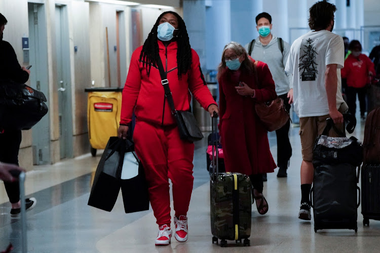 Travellers carrying luggage walk through a terminal at Los Angeles International Airport (LAX) during the holiday season as the Omicron variant threatens to increase Covid-19 case numbers in Los Angeles, California, US, on December 22 2021.