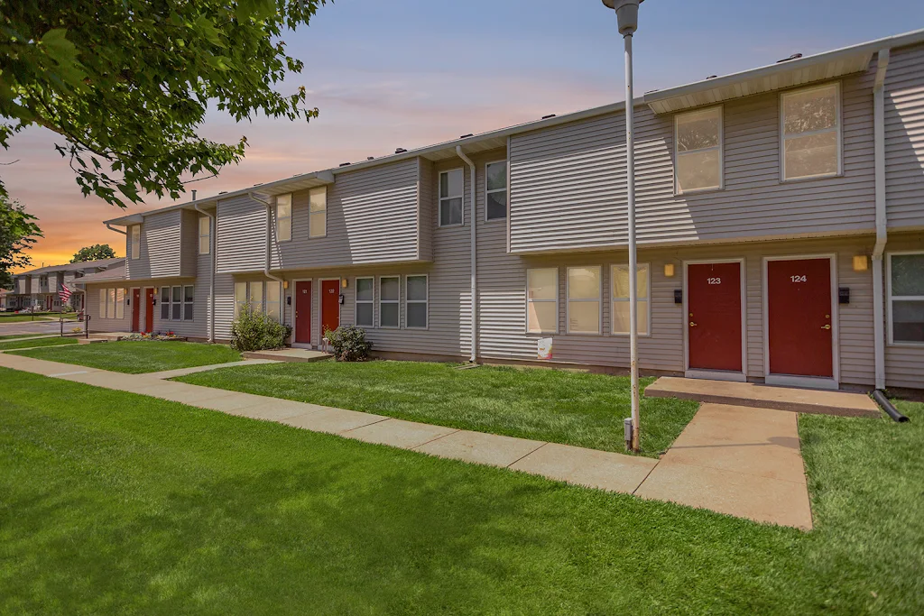 Cedar Tree apartment building with light brown siding at dusk