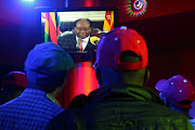 People watch as Zimbabwean President Robert Mugabe addresses the nation on television, at a bar in Harare, Zimbabwe, November 19, 2017.