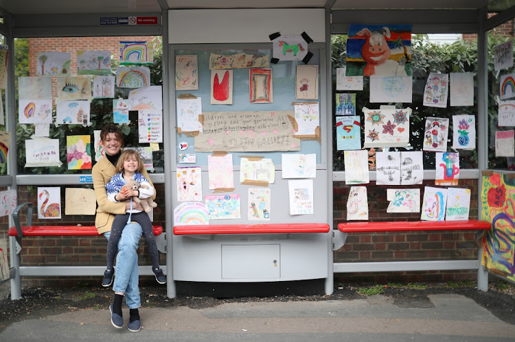 SPREADING THE LOVE: Sarah Lamarr and her daughter, Rosie, 4, who transformed a London bus stop into a children’s art gallery, pose for a photograph on Monday. Lamarr started the project to bring cheer to people during the Covid-19 lockdown in the UK