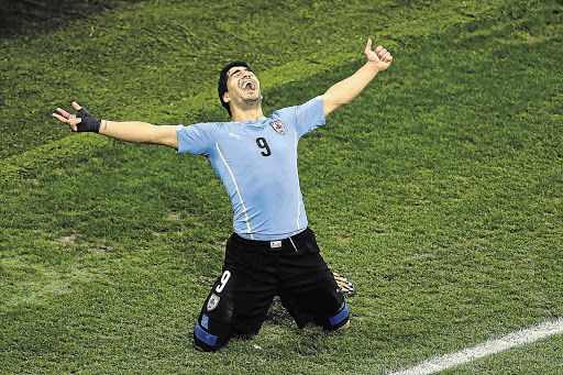 DOUBLE TROUBLE: England's bete noir, Luis Suárez, celebrates his second goal in the Group D match against England at Arena de Sao Paulo last night. Suárez scored two goals and England are now under intense pressure if they are to stay in Brazil